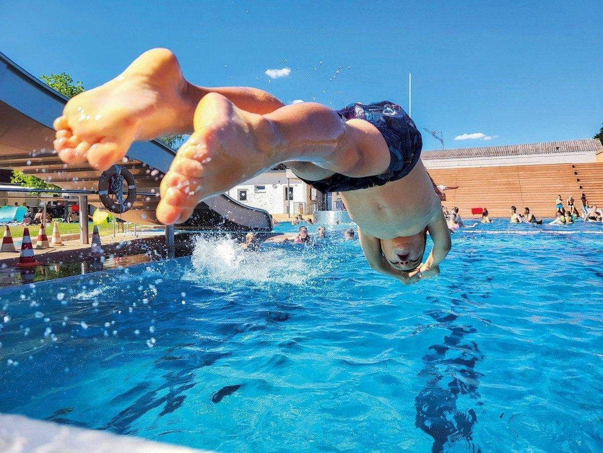 Kind springt mit Köpfer ins Freibad